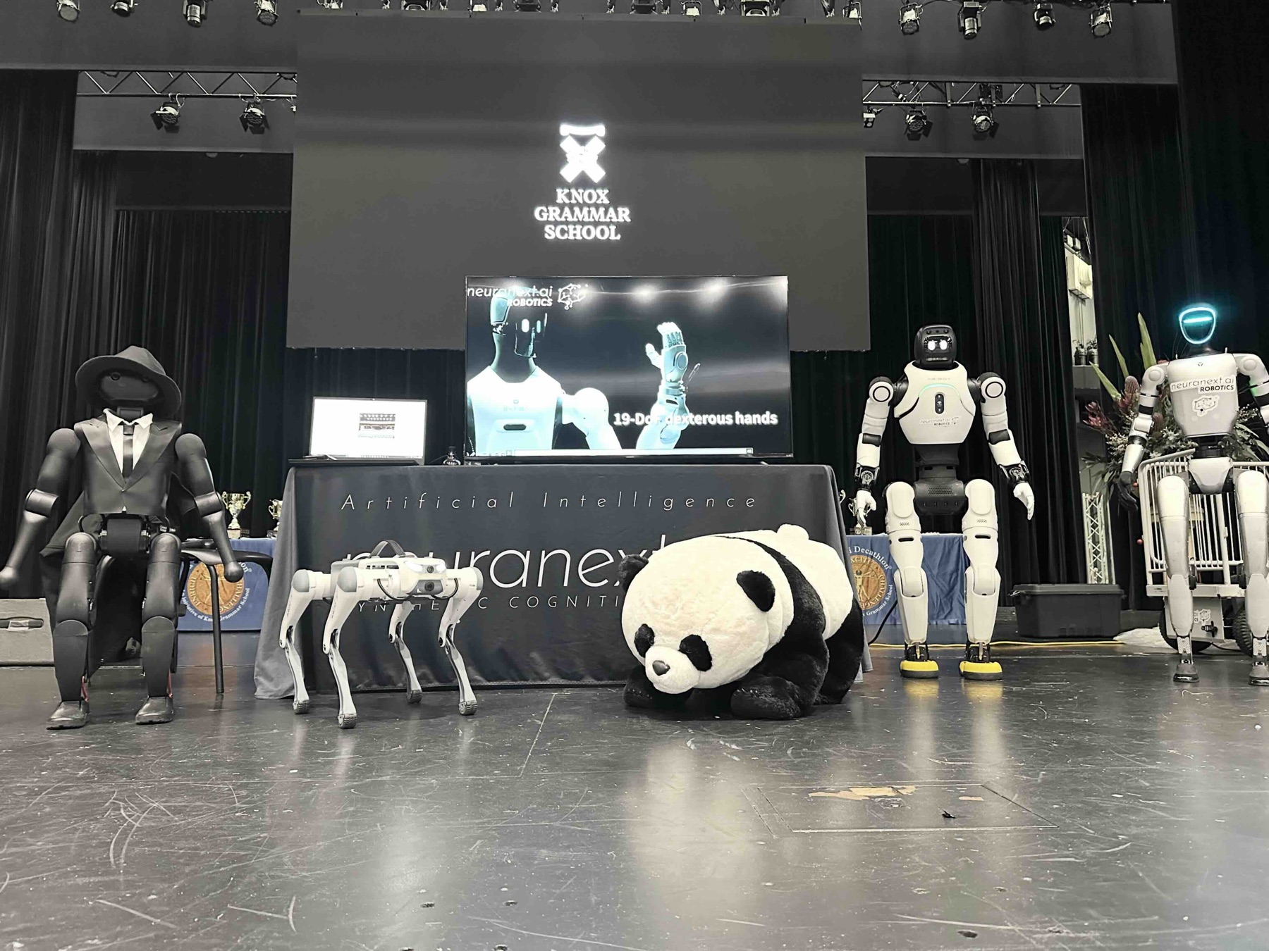 Humanoid and quadruped robots displayed on stage at Knox Grammar School