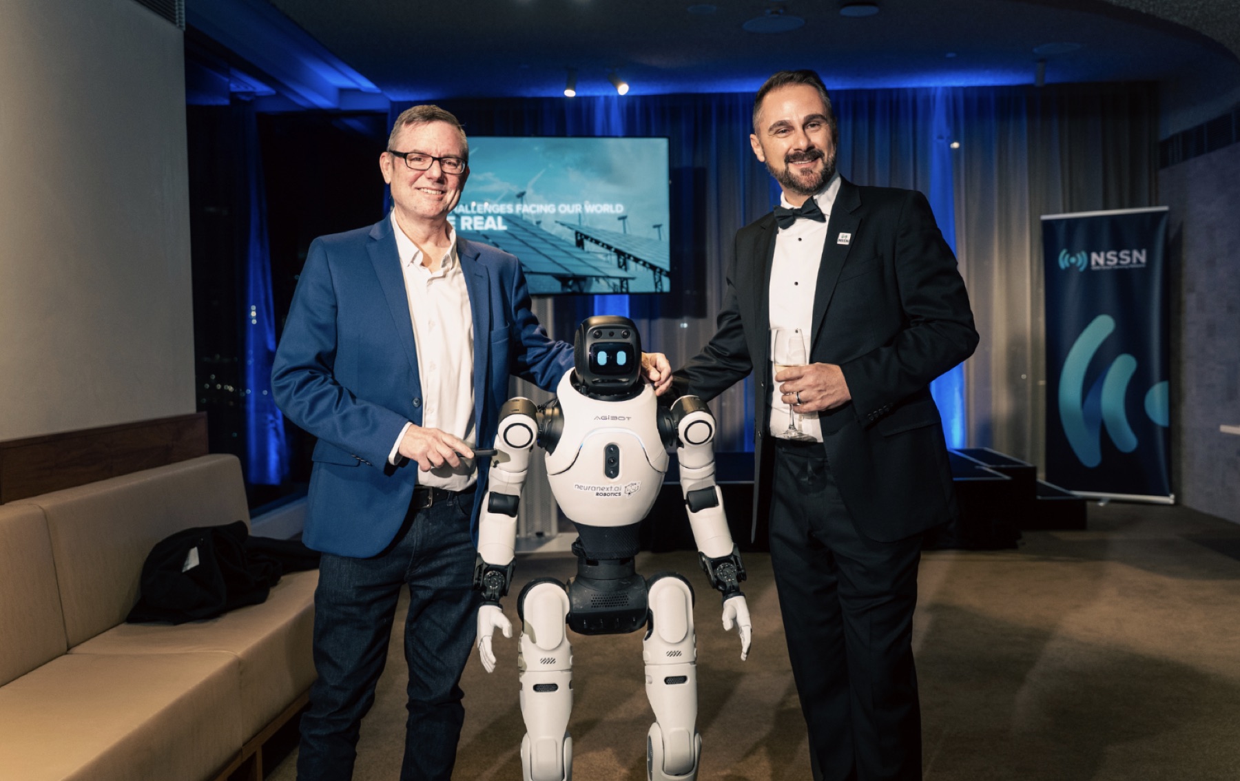 Adrian Tyson and a guest with an AGIBOT humanoid robot at an NSSN event
